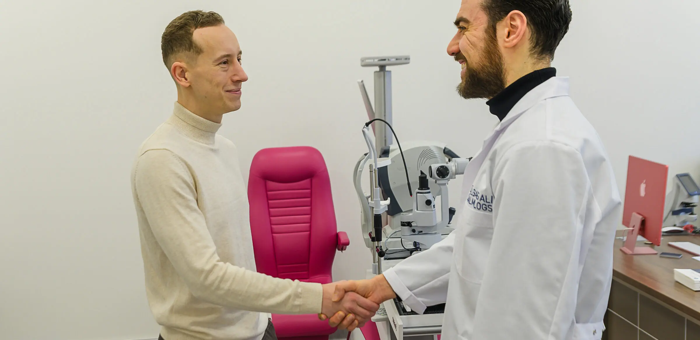 Dr. Ali sasveicinās ar pacientu izmeklējumu kabinetā